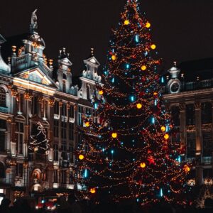 a lit christmas tree in front of a building